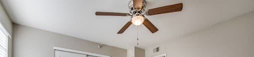 A room with a ceiling fan and wooden floors.