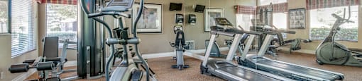A well-equipped gym with treadmills, elliptical machines, and other exercise equipment.