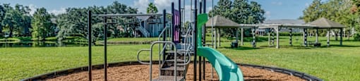 A playground with a green slide and a metal structure.