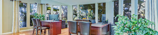 a dining room with a table and chairs and a living room with windows