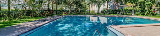 a swimming pool with trees in the background