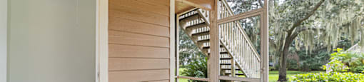 a sliding glass door opens to a porch with a view of a staircase