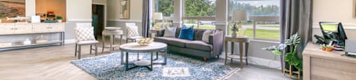 A spacious living room with a large window overlooking a green landscape.