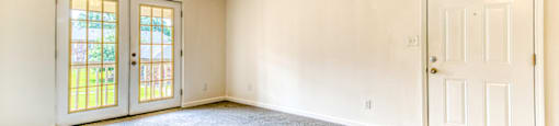 A room with a ceiling fan and two doors.