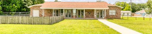 A house with a green lawn in front of it.
