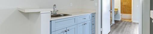 an empty kitchen with blue cabinets and a sink