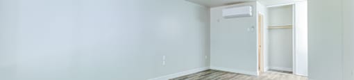 an empty living room with wood flooring and blue walls