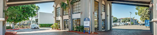 a large building with a driveway and a parking garage