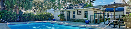 A swimming pool surrounded by a brick patio and trees. at Westminster Chase Apartments, Tampa, FL, 33616