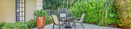 A patio with a table and chairs under an umbrella. at Westminster Chase Apartments, Florida, 33616