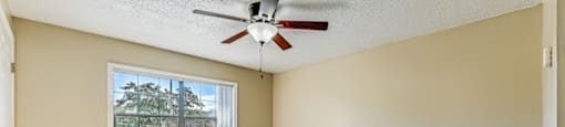 A room with a ceiling fan and a window. at Westminster Chase Apartments, Apartments, Tampa, FL