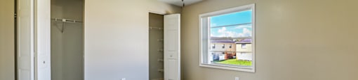 A room with a ceiling fan and a window showing a view of a house at Westminster Chase Apartments, Tampa, FL, 33616