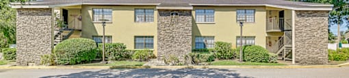 A sunny day at a stone and stucco apartment complex at Westminster Chase Apartments, Tampa, 33616
