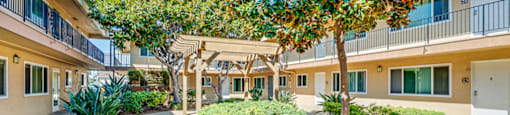 A sunny day at a residential complex with a walkway and trees.