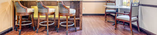 a dining room with tables and chairs and a bar