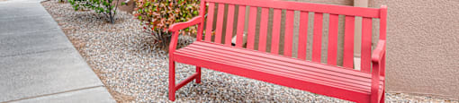 a red bench sitting outside of a building