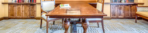 a library with a table and chairs and bookshelves