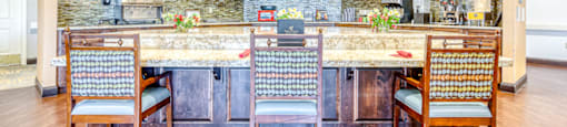 a kitchen with a bar and chairs in a house