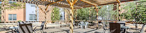 a covered patio with tables and chairs under a roof