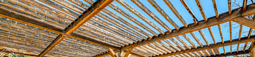 a patio with a table and chairs under a roof