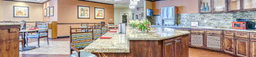 a large kitchen with a marble counter top and a dining area