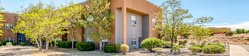 a building with a yard and trees in front of it
