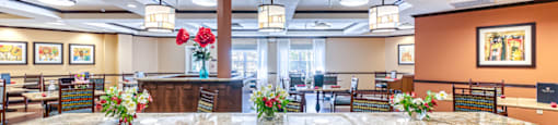 a large lobby with a large table with flowers and chairs