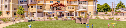 large lawn near community with lawn games and patio seating