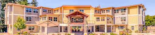 large lawn in front of community with patio seating