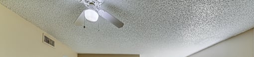 A room with a ceiling fan and wooden flooring. at Green Oaks Apartments, Tampa, Florida
