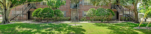 A house with a driveway and trees in front at Green Oaks Apartments, Apartments, Tampa, FL