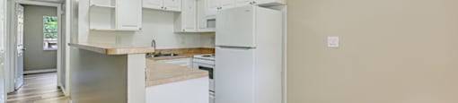 A kitchen with white appliances and wooden floors at Green Oaks Apartments, Florida, 33616