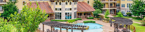 A large apartment complex with a pool and a gazebo.
