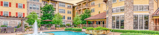A large outdoor pool with a fountain in the middle of a residential area.