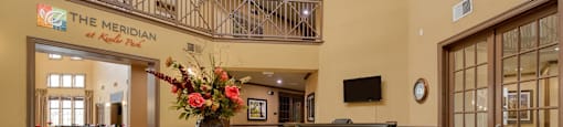 The lobby of The Meridian is shown with a large wooden table in the center.