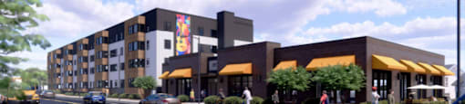 A street view of a building with cars and people.