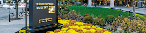 a commemorative sign in front of a park with flowers at Presidential Towers, Illinois, 60661