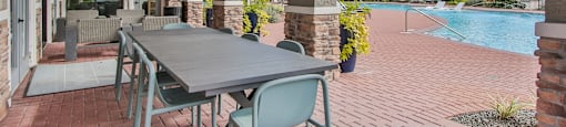 an outdoor patio with a table and chairs and a swimming pool at Sladestone Shadow Creek, Pearland, TX
