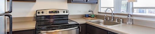 a kitchen with stainless steel appliances and dark wood cabinets at Presidential Towers in Chicago, 60661