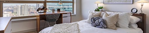 a bedroom with a bed and a view of the city at Presidential Towers in Chicago, IL
