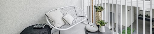 a balcony with a chair and a palm tree at OLiVE DTLA in Los Angeles, CA 90015