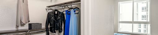 a bedroom with a bed and a closet with clothes rails and a window