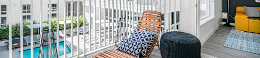 a balcony with two chairs and a bench and a swimming pool at OLiVE DTLA in Los Angeles, California 90015