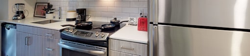 a kitchen with a stove and a refrigerator at OLiVE DTLA in Los Angeles, CA