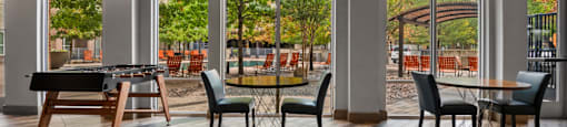 a clubhouse with tables and chairs and large windows at South Side Flats, Dallas, 75215