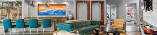 a living room with a green couch and chairs and a bar at South Side Flats, Dallas, Texas