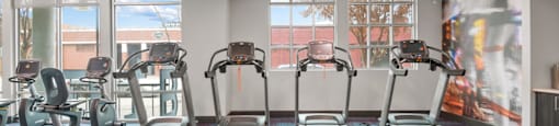 a gym with cardio machines and windows in a building at South Side Flats, Texas