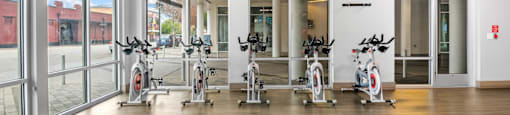 the gym with treadmills and ellipticals at the belgard apartments at South Side Flats, Dallas, TX