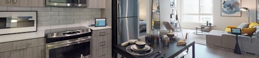 a kitchen with stainless steel appliances and a black table at OLiVE DTLA in Los Angeles, 90015
