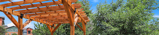 a picnic area with benches and tables and a pergola at Switchback on Platte Apartments, Colorado